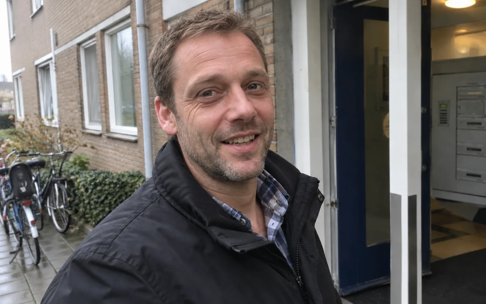 A man standing outside an apartment building